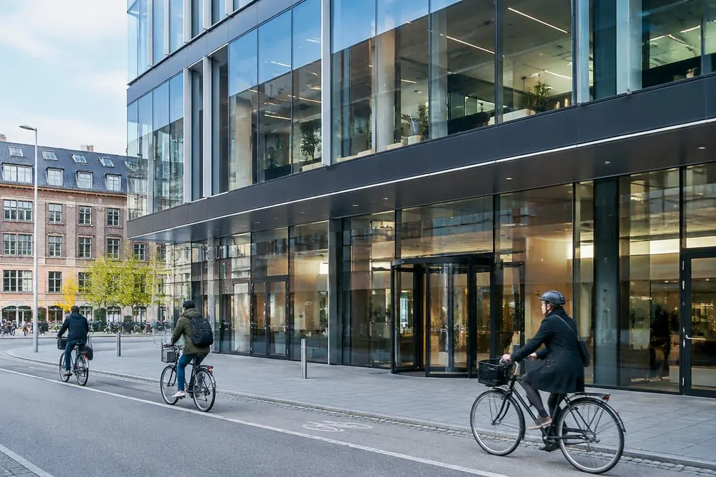 Moderne bankbygning i København med cyklister foran facaden.